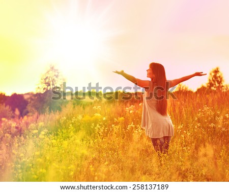 Free Happy Woman Enjoying Nature. Beauty Girl Outdoor. Freedom concept. Beauty Girl over Sky and Sun. Sunbeams. Enjoyment. Summer Meadow.