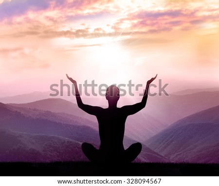 Yoga and meditation. Silhouette of man in the mountain