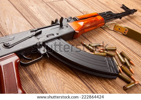 Kalashnikov assault rifles with ammunition on a wooden table