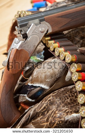 Gun, hunting, a dead duck, and ammunition on the table