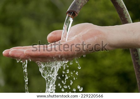 man\'s hand under running cold water
