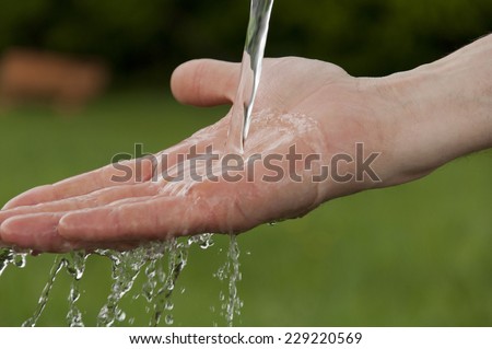 man\'s hand under running cold water
