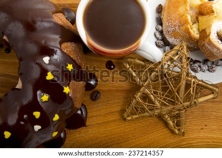 Christmas cake with a cup of hot chocolate and a star on the wooden background