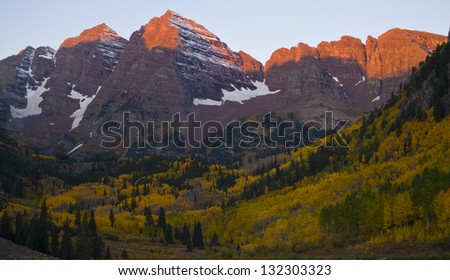 Sunrise on the Bells. The first light of a cold fall sunrise illuminates the twin peaks of the Maroon Bells outside Aspen, Colorado.