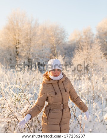 Young girl walking in winter forest
