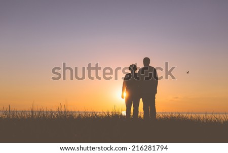 Senior couple holding hands silhouettes