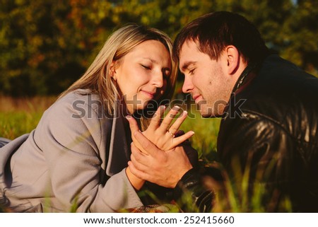 Man tries on ring on a finger girl lying on a meadow
