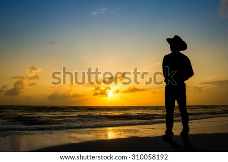 Men wore hats stood watch The sun rises in the morning at the beach.