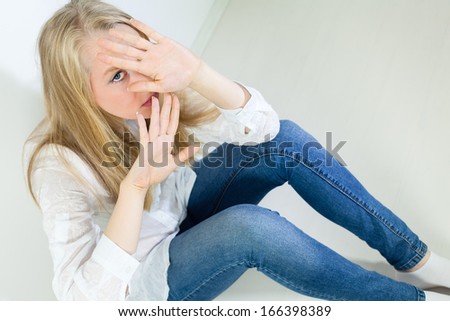 Scared Young Woman holding her hands up to say Stop