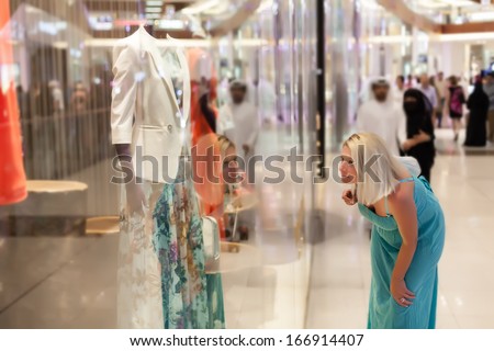 Beautiful mid age woman looking about the merchandise.Soft focus, shallow doff , Dubai shopping mall