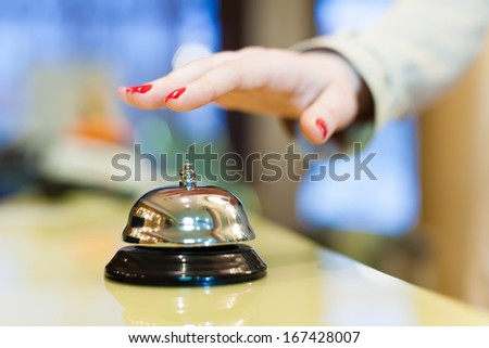 A female hand ringing silver service bell