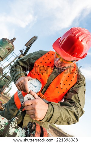 Oil field working controlling natural gas pressure in barometer.Refinery theme