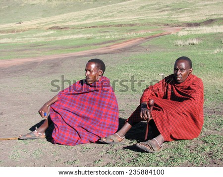 TANZANIA, AFRICA - NGORONGORO, 26 JANUARY 2006. Masai people sitting outdoors on the grass, looking away