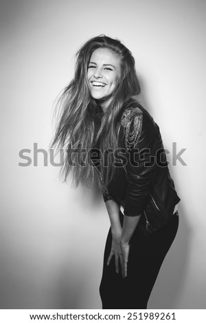 a beautiful girl laughs in studio in black jacket