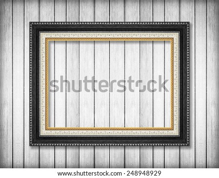 Antique picture frame on white wooden wall ;. Empty picture frame on white wooden wall.