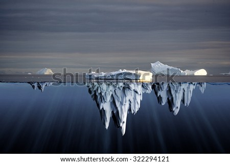 Above and below water view of icebergs in the Antarctica showing the volume of ice below the surface of the ocean and the consequent danger to shipping
