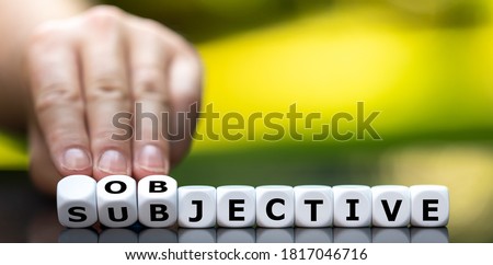 Hand turns dice and changes the word 'subjective' to 'objective'. Foto stock © 