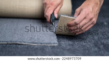 Handyman cutting a new carpet with a carpet cutter..	 Stockfoto © 