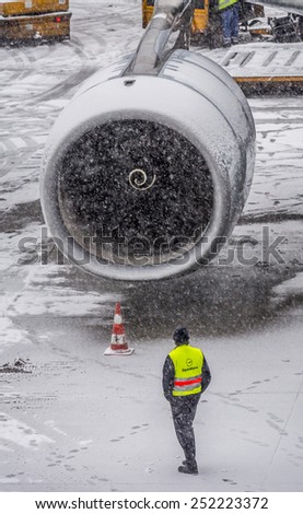 Munich - 30 dec 2014: Airbus 340 plane engine details, parked at the terminal under heavy snow, wait to be prepared by the operators for takeoff