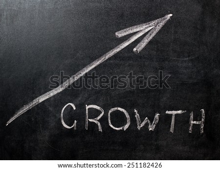 Direction to growth on a black chalkboard with chalk dust