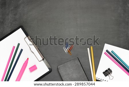 Still life, business, education concept. Office supplies, notepad, diary, marker, clips and pencils on a chalkboard. Selective focus, copy space background, top view