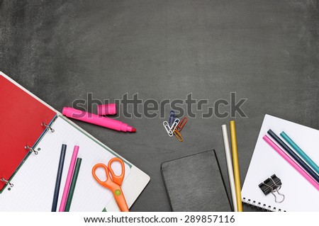 Still life, business, education concept. Office supplies, notepad, diary, marker, scissors and pencils on a chalkboard. Selective focus, copy space background, top view