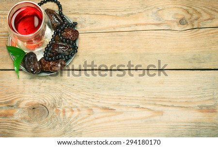 Still life, food and drink, holidays concept. Ramadan dates, tea and beads on a wooden table. Selective focus, copy space background, top view