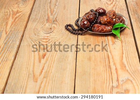 Still life, food and drink, holidays concept. Ramadan dates and beads on a wooden table. Selective focus, copy space background