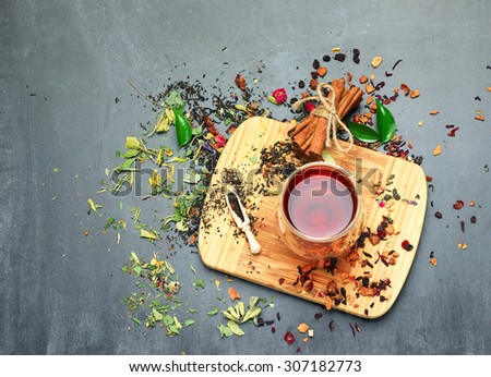 Still life, food and drink concept. Various kinds of tea with a glass of tea on a black chalkboard. Selective focus, copy space background, top view.