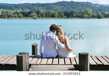 A couple on the wooden jetty at the lake. Switzerland