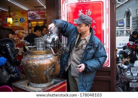 TIANJIN, CHINA - FEBRUARY 2, 2014: Restaurant Tea Soup. Waiter pouring hot water to the teapot. Located in Tianjin Ancient Culture Street, FEBRUARY 2, 2014 in Tianjin City, China.