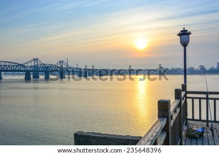 Yalu River Bridge and Yalu River Scenic Areas at morning. In the distance is North Korea. Located in Dandong City, Liaoning province, China.
