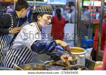 Shenyang, China - May 10, 2015: Chinese chef selling Stinky Tofu. Located in Xingshun International Tourist Night Market, Shenyang City, Liaoning province, China.