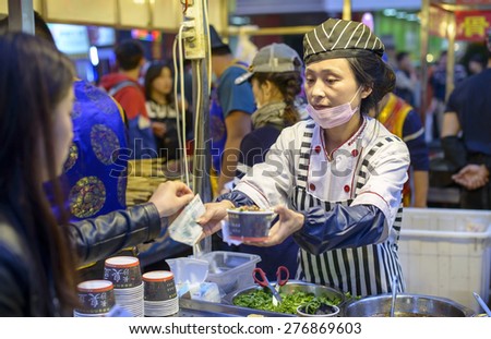 Shenyang, China - May 10, 2015: Chinese chef selling Stinky Tofu. Located in Xingshun International Tourist Night Market, Shenyang City, Liaoning province, China.