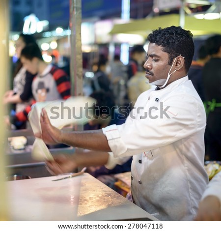 Shenyang, China - May 10, 2015: Indian chef making Indian flying cake. Located in Xingshun International Tourist Night Market, Shenyang City, Liaoning province, China.