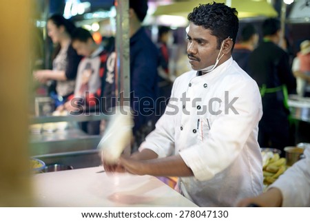 Shenyang, China - May 10, 2015: Indian chef making Indian flying cake. Located in Xingshun International Tourist Night Market, Shenyang City, Liaoning province, China.