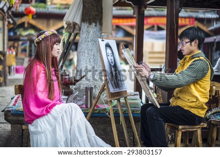 Lijiang, China - March 30, 2014: Young artist drawing girl portrait. Located in Old Town of Lijiang, Yunnan Province, China.