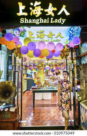 Beijing, China -  August 18, 2015: Wangfujing Snack Street at night. Shanghai Lady Shop. Chinese waiter waiting for the guests. Located in Beijing, China.