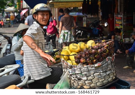 HO CHI MINH CITY, VIETNAM - CIRCA OCTOBER 2013 - Street vendor selling tropical fruits from his bicycle on the busy street