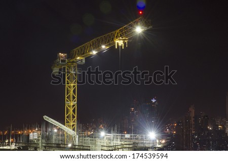 Crane on top of under construction building at night