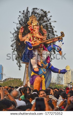 Mumbai, India - September 17, 2013 - Devotee bringing Hindu God Ganesha into the ocean during Ganesha Festival