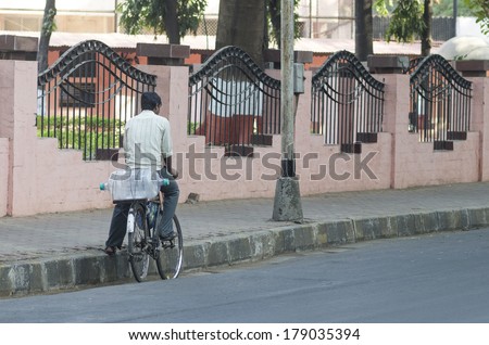 MUMBAI, INDIA - FEBRUARY 8, 2014: Man delivering drinking water from his bicycle near Colaba market