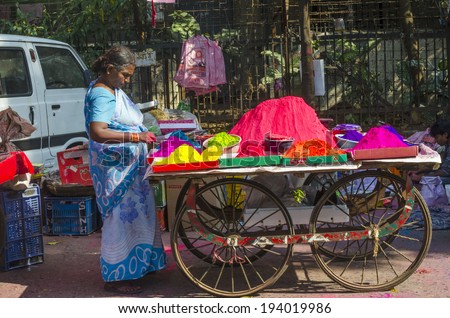 MUMBAI, INDIA - MAR 15, 2014 - Woman selling selling colorful powder  during Holi Festival at local market