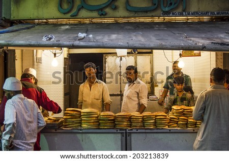 Mumbai, India - July 3, 2014 -  Men selling freshly baked breads from stall at at crowded Mohammad Ali Road in the evening during Ramzan fasting month