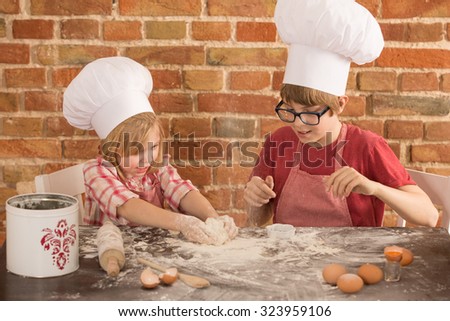 two young chefs, baking a cake