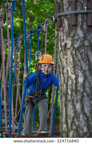 boy climbing in adventure park , rope park
