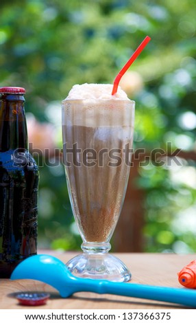 Root beer float outdoors with ice cream scoop and bottle