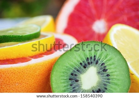Fresh colorful tropical fruits and slices - kiwi, lemon, lime, red grapefruit