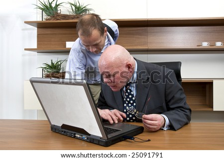An IT consultant assisting a company director with his laptop