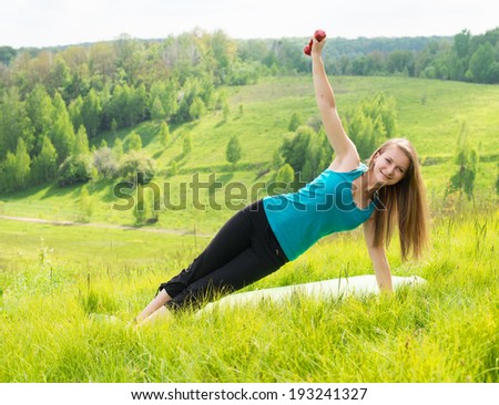 Girl doing yoga in nature. Beautiful nature background. Young woman workout outdoors.